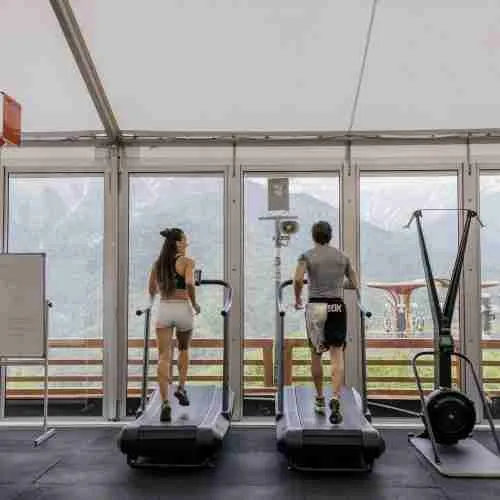 man and woman exercising on a treadmill at the gym