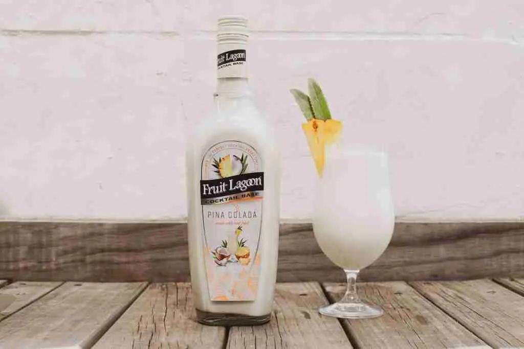 a bottle of alcohol sitting next to a glass pina colada Classy Alcoholic Drinks for Ladies