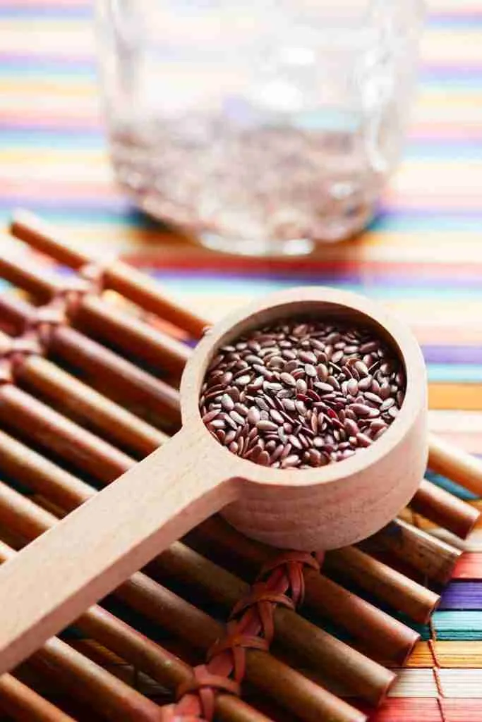 flaxseeds in wooden spoon prepared to make flaxseed face mask